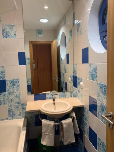 a bathroom with a sink and a tub and a mirror at Penthouse 160sqm wide Terraces Pool view & private Hot Tub & Parking in Albufeira