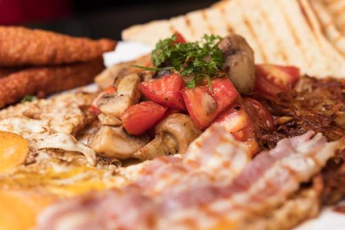 a plate of food with meat and strawberries on it at Red Mango Hotel and Apartments in Takoradi
