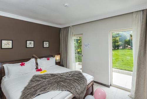 a bedroom with a bed and a large window at Red Mango Hotel and Apartments in Takoradi