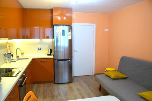 a kitchen with a refrigerator and a couch in it at Apartment Visagina in Visaginas