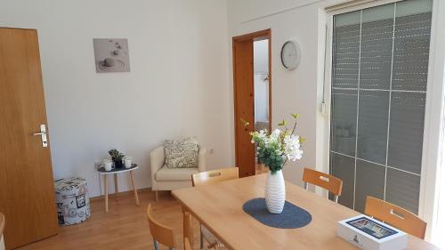 a dining room with a table with a vase of flowers on it at Apartments Luna in Sveti Filip i Jakov