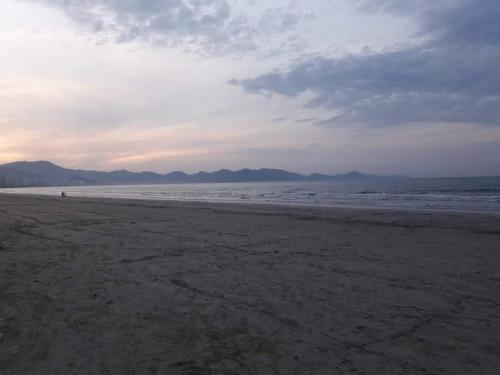 una playa vacía con el océano y un cielo nublado en Ed Hang, en Porto Belo