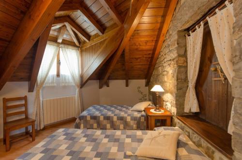 a bedroom with two beds and a wooden ceiling at Apartamentos Casa Aneta in Sarvisé