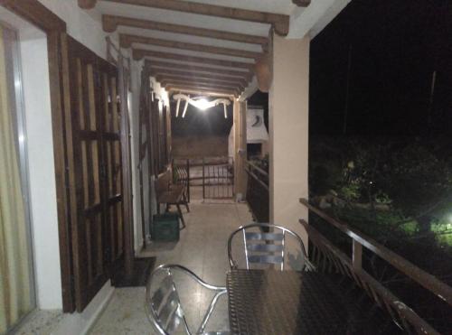 a table and chairs on a porch at night at Casa Rural El Arroyo in Sotoserrano
