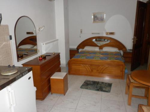 1 dormitorio con cama, lavabo y espejo en Miramare Hotel, en Lakkíon