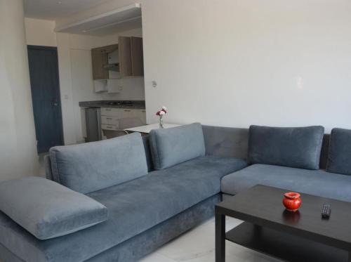a living room with a blue couch and a table at Crystal Palace Oualidia in Oualidia