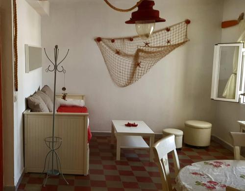 Habitación pequeña con mesa, cama, mesa y sillas. en Auténtica vivienda de pescadores en primerísima línea de playa, en Villajoyosa