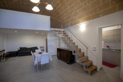 a living room with a spiral staircase and a table at La Casa di Montegrosso in Matera