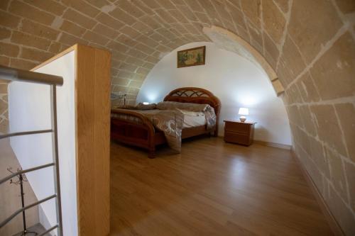 a bedroom with a bed and a brick wall at La Casa di Montegrosso in Matera