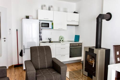 een keuken met een fornuis en een stoel in een kamer bij Apartmán Reggie - Pec pod Sněžkou in Pec pod Sněžkou