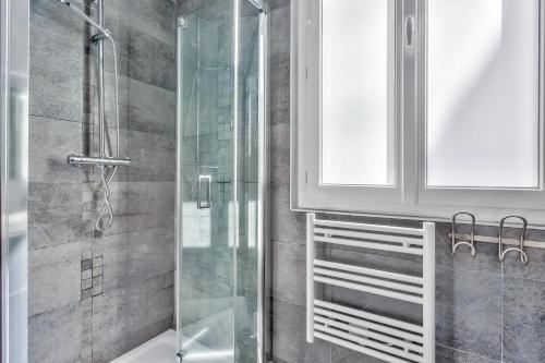 une salle de bain avec une douche avec une porte vitrée dans l'établissement Amazing 2 Rooms Flat near Bastille - An Ecoloflat, à Paris