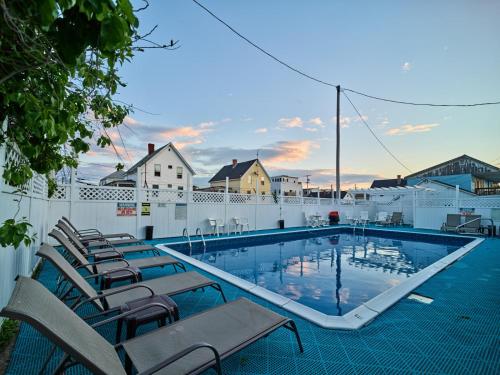 a large swimming pool with chairs and a fence at Hillcrest Inn in Hampton