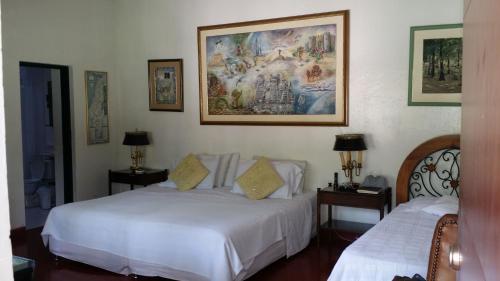 1 dormitorio con 2 camas y un cuadro en la pared en Finca Kenya, en La Vega