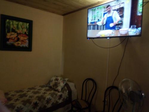 sala de estar con TV de pantalla plana en la pared en El patio de marta en Posadas