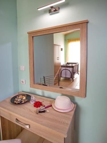 a mirror on the wall above a wooden vanity with a table at Lazy Lizard in Néa Karváli