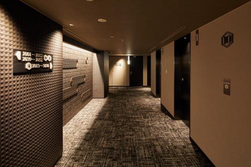 an empty hallway with a sign on a brick wall at Via Inn Prime Kyotoeki Hachijoguchi in Kyoto