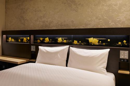 a bedroom with a bed with white pillows at Via Inn Prime Kyotoeki Hachijoguchi in Kyoto
