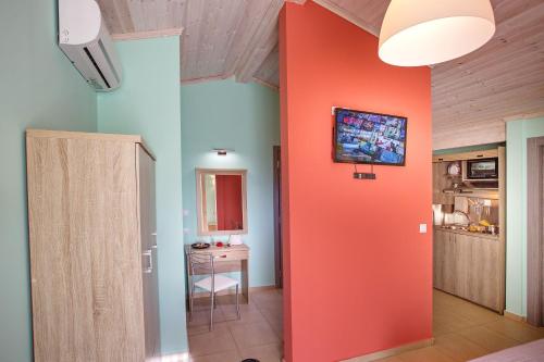 a hallway with an orange wall in a room at Lazy Lizard in Néa Karváli