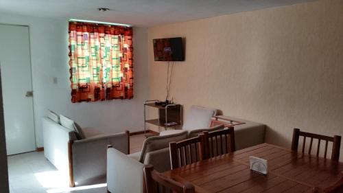 sala de estar con mesa, sillas y TV en Casa Pachuca hidalgo, en Colonia de Venado