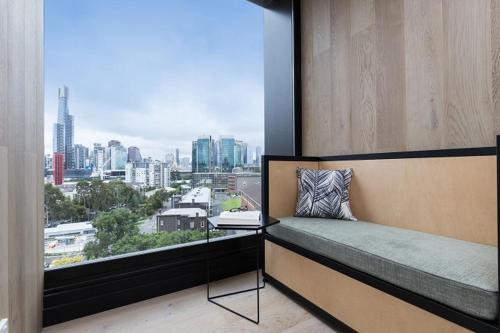 a bedroom with a window with a view of a city at Saint Domain in Melbourne