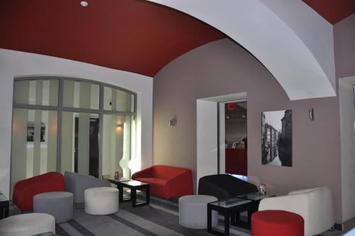 a waiting room with red and white chairs and tables at Red & Blue Design Hotel Prague in Prague