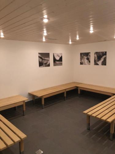 a row of benches in a room with pictures on the wall at Rancho Laaxdeluxe in Laax
