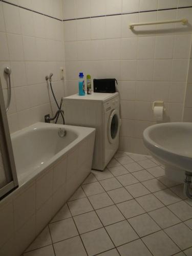 a bathroom with a washing machine and a tub and a sink at Haus Moezelblik - schöne Aussicht am Mosel in Zell an der Mosel