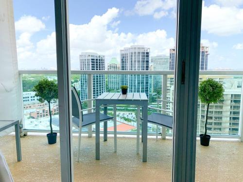 a table and chairs on a balcony with a view of a city at City View Balcony steps from Restaurants, Peacock Park & Marina in Miami