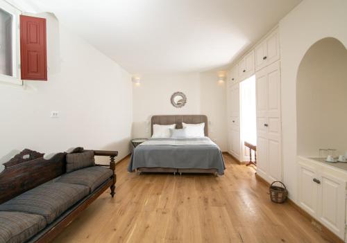 a bedroom with a bed and a couch at Aloia Villas in Oia