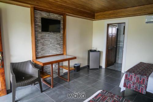 a room with a desk and a bed and a tv at Campos Arenal Hotel in Fortuna
