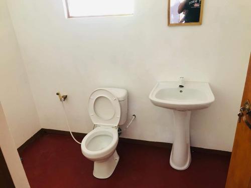 a bathroom with a toilet and a sink at Rivosen Camp Yala Safari in Yala