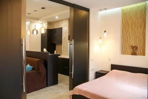 a small bedroom with a bed and a kitchen at Apartment Luxe Paris in Odesa