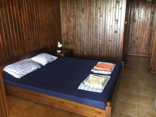 a bedroom with a bed in a wooden wall at Дървени къщички - Лион in Sinemorets