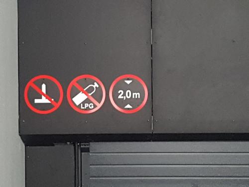 a sign on a wall withhibited signs on it at HaPPy Inn Emporia, Self chek-in, Parking in the underground garage in Vilnius