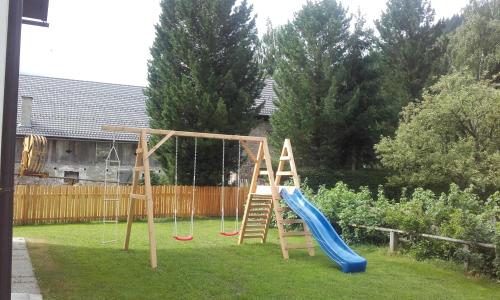 a playground with a slide in a yard at Ferienhaus Reinfrank in Sankt Michael im Lungau