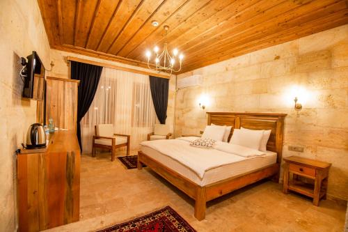 a bedroom with a bed and a wooden ceiling at ikarus Cappadocia Hotel in Uchisar