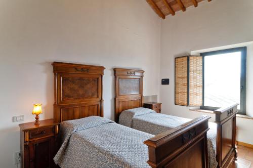 a bedroom with two beds and a window at Le 7 Camicie in Castelnuovo dellʼAbate