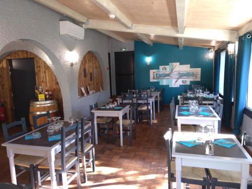 uma sala de jantar com mesas e cadeiras num restaurante em LES VOYAGEURS em Vogüé