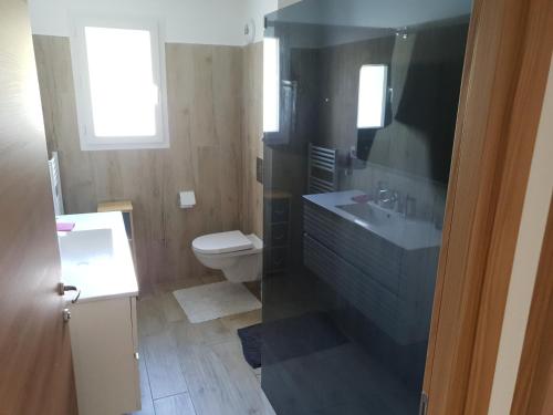 La salle de bains est pourvue d'un lavabo et de toilettes. dans l'établissement Appartement Confortable, à Biguglia