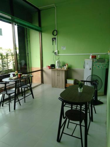 a kitchen with two tables and a refrigerator at Auntie House985 in Phra Nakhon Si Ayutthaya