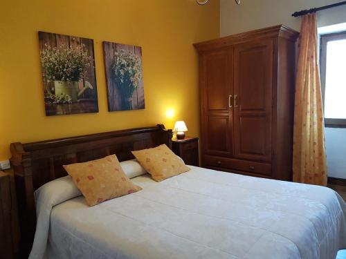 1 dormitorio con 1 cama blanca grande y 2 almohadas en Casa Rural Petisansenea II, en Zuaztoy de Azpilcueta