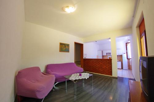 a living room with purple chairs and a table at Large and charming apartment near beach with big & sunny terrace in Sumartin