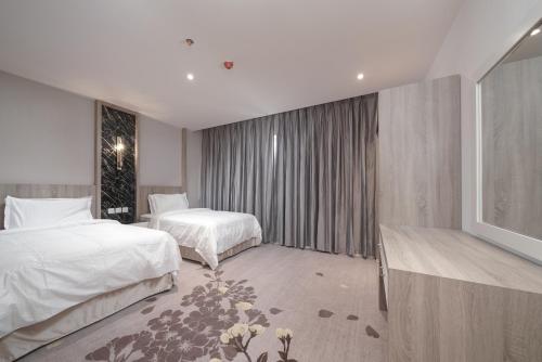 a hotel room with two beds and a television at Swiss In Park Tabuk in Tabuk
