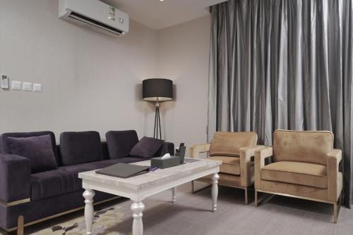 a living room with a couch and two chairs and a table at Swiss In Park Tabuk in Tabuk