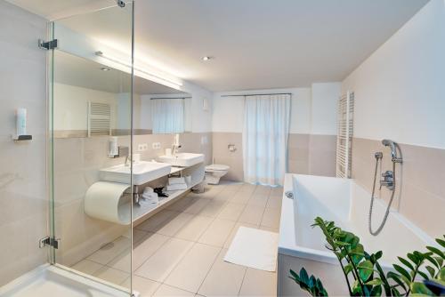 a bathroom with two sinks and a shower at Hotel Steinerwirt1493 in Zell am See