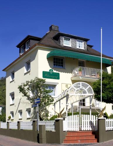 a white building with a white fence in front of it at Gästehaus Hotel Rheingraf in Kamp-Bornhofen
