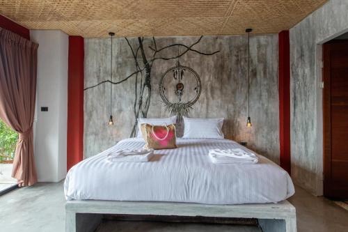 a bedroom with a large white bed with red accents at Dreamcatcher Boutique Hotel in Bophut 