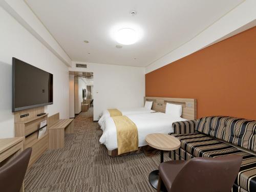 神戸市にあるホテルサンルートソプラ神戸のベッド1台、薄型テレビが備わるホテルルームです。