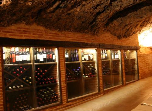 a wine cellar with a bunch of bottles of wine at Hostal Restaurante La Muralla in Oña