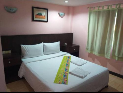 a bedroom with a bed with a tie on it at Cha-Am Fish Star in Cha Am